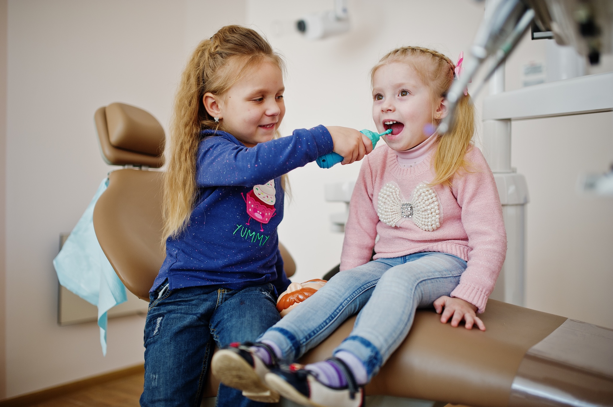 Two cutie little baby girls at dentist chair. Children dental.